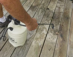 Deck cleaner applied with low-pressure garden sprayer.