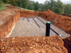 A conventional leach field uses perforated pipes in gravel trenches.